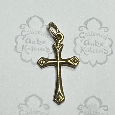 Bronze cross pendant with decorative ends and a small loop at the top, set against a light background.